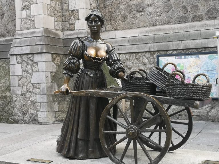 Molly Malone Statue, a bronze statue of a woman in a long dress pushing a cart with baskets.