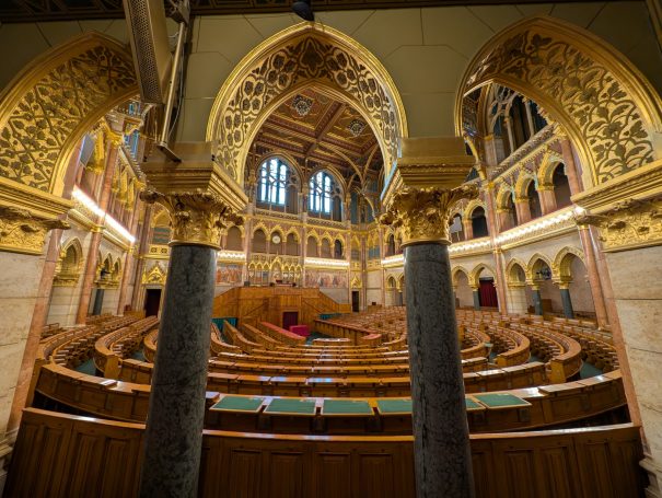Interior of a grand legislative chamber with ornate arches and wooden seating, known as The Chamber of Peers.