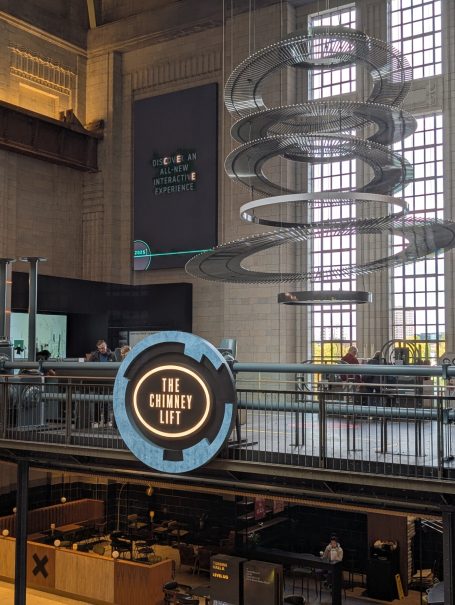 Modern interior with spiral sculptures and a café area in an urban space.