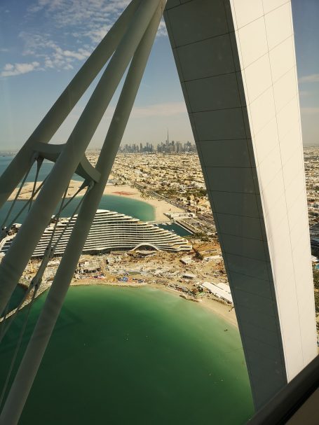 View from a high structure overlooking a coastal cityscape and turquoise waters.