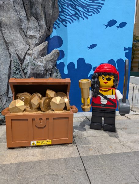 Lego pirate figure next to a treasure chest filled with gold pieces at Legoland Malaysia