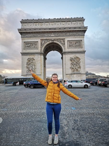 I&B's Founder posing with her arms raised in from the of Arc de Triomphe in Paris