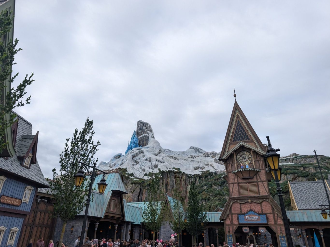 Snow-capped mountain towers over whimsical buildings in a themed village setting.