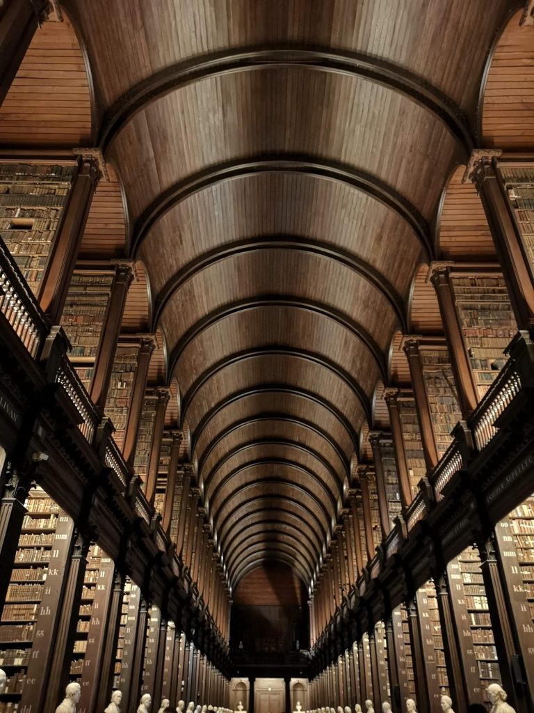 Wooden ceiling arches above rows of bookshelves in the Long Room library at Trinity College in Dublin.