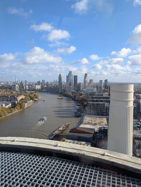 View of the River Thames with London skyline in the background and blue sky.