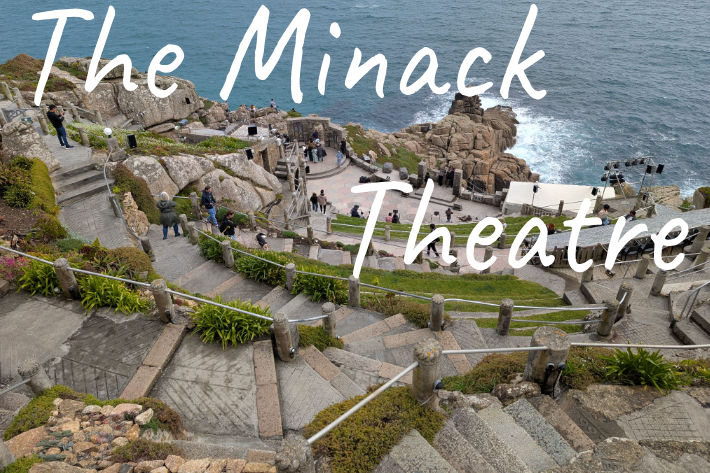 The Minack Theatre on a cliffside with ocean views and stone seating steps.