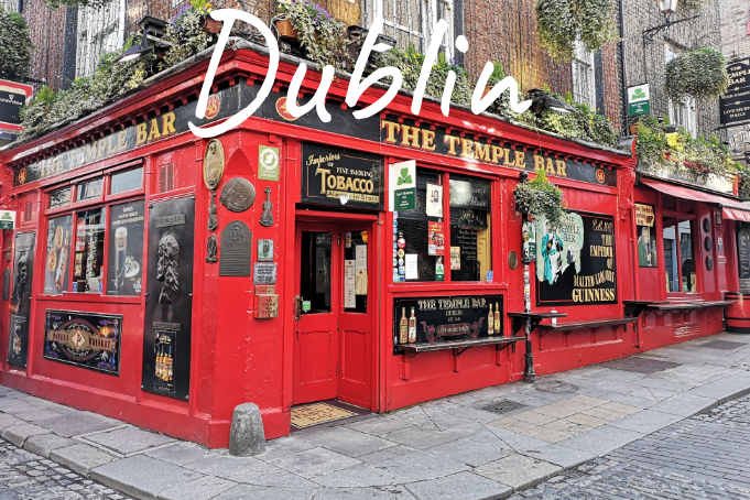 The Temple Bar exterior, bright red pub adorned with greenery, located in Dublin.