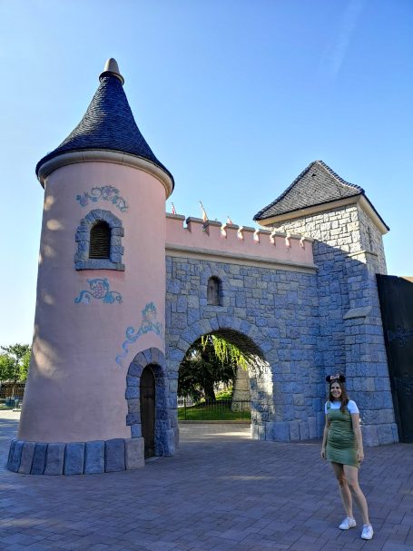 I&B's Founder posing with a small, pink castle in the background, located in Disneyland Paris.