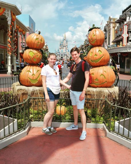 I&B's Founder & Husband posing with pumpkins and Main Street USA in the background, located at Magic Kingdom.