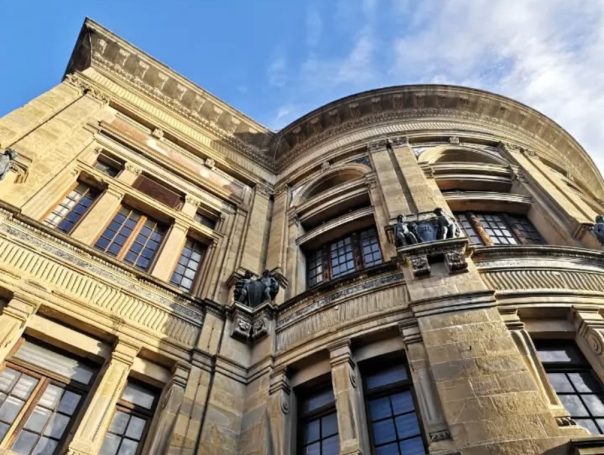 The historic Florence National Central Library building with detailed architecture and large windows against a clear blue sky.