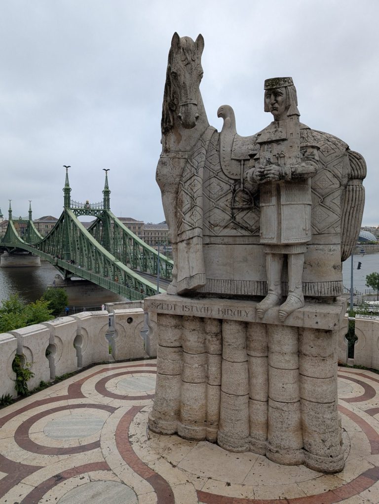Szent István Király szobra statue with the green Liberty Bridge in the background in Budapest