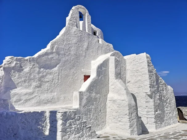 Church of Panagia Paraportiani in Mykonos against a clear blue sky.