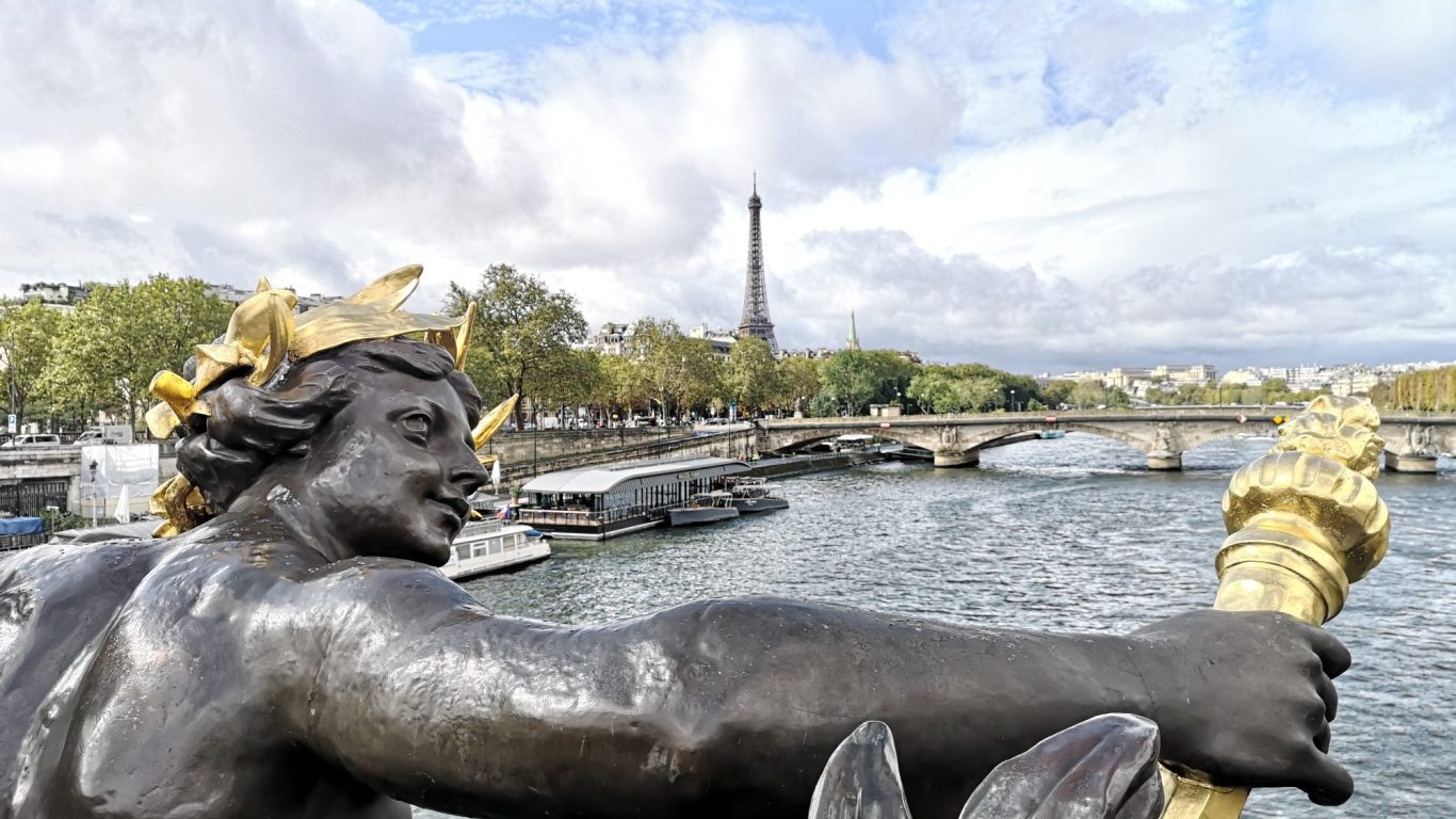 Statue overlooking the Seine River with the Eiffel Tower in the background.