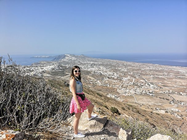 I&B's Founder posing with the landscape of Santorini and the coastline in the background.