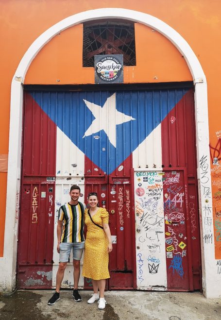 I&B's Founder & Husband posing in front of the Puerto Rico Flag Door on Callejón de la Puerta con la Bandera in San Juan
