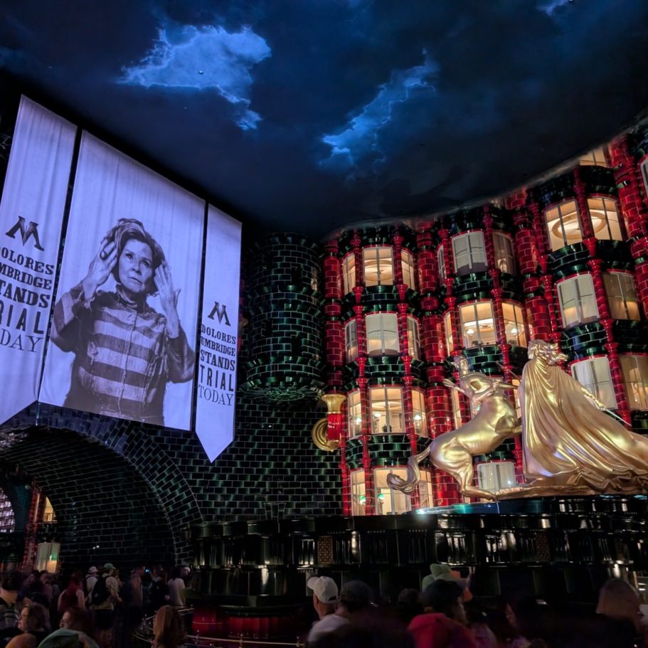 Interior of a vibrant venue featuring a large screen and golden sculptures.