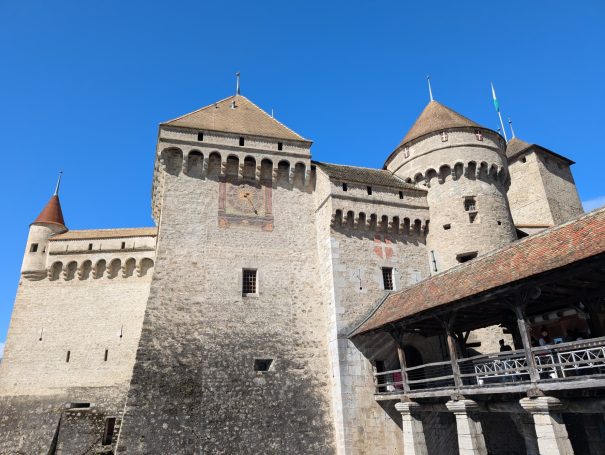 Chillon Castle with towers against a clear blue sky.