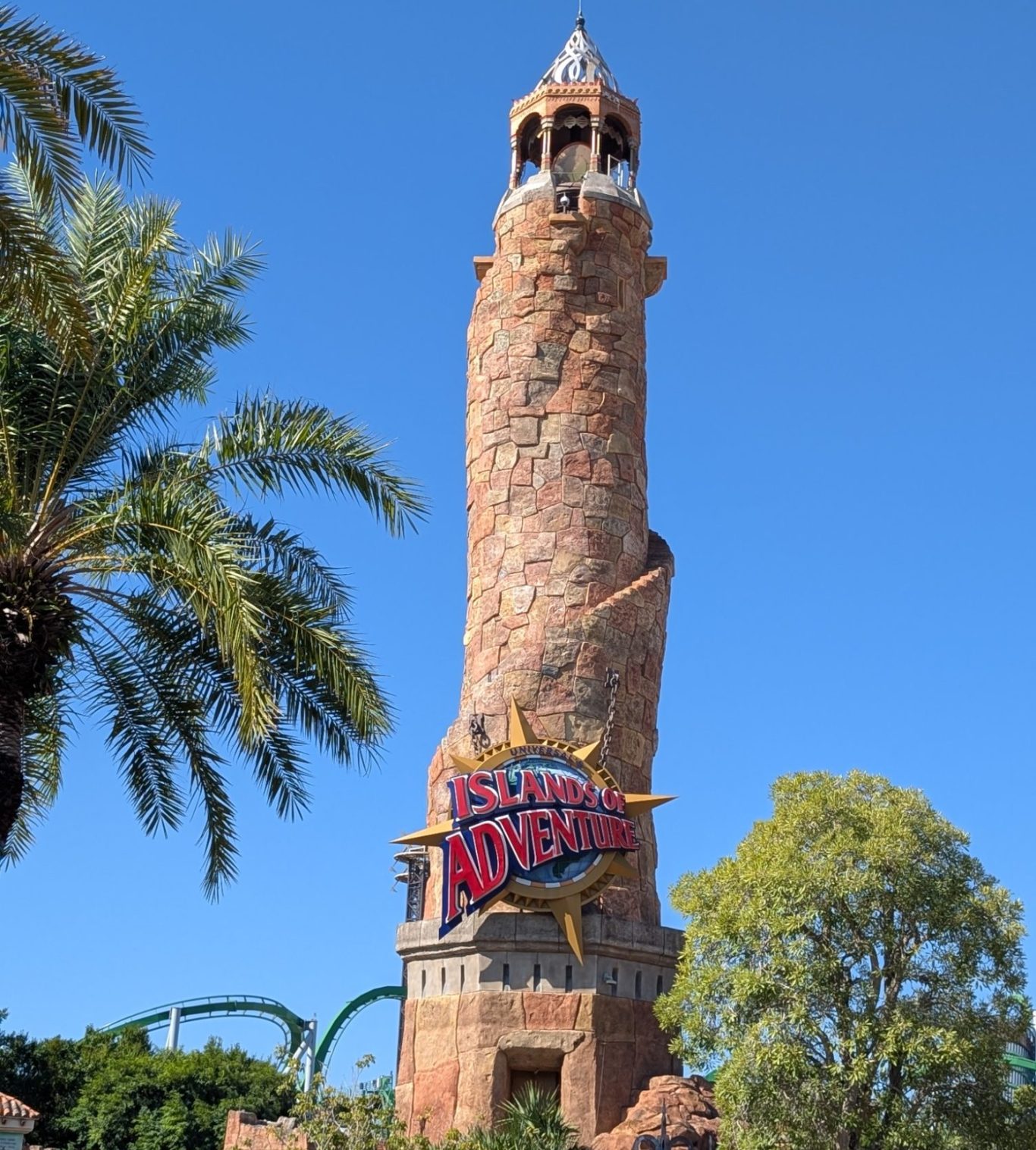 Tall stone tower with a spiral design and a vibrant sign reading "Island Adventure" below.