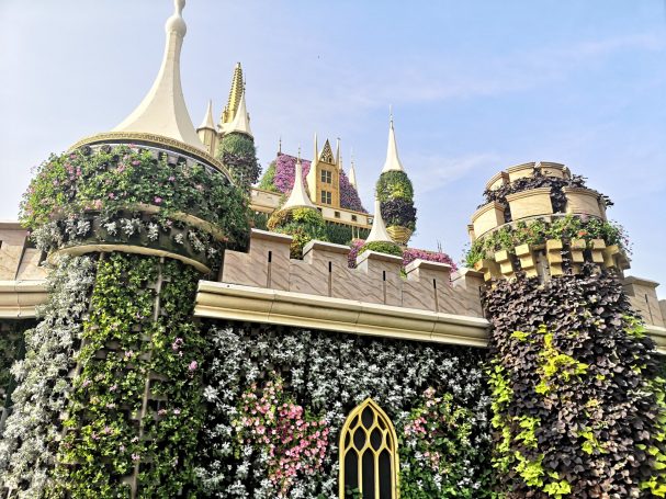 Fairytale castle adorned with lush greenery and vibrant flowers, located in Dubai Miracle Garden