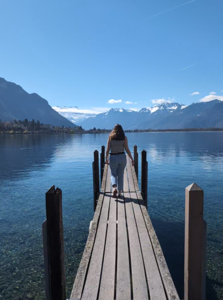 I&B Founder walking along a wooden pier located at Chillon Castle, with lake Geneva and mountains in the background