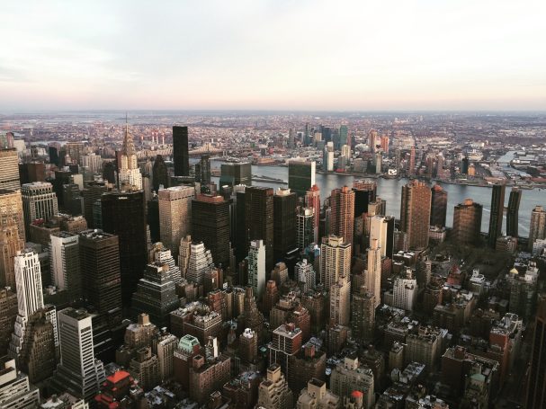 Aerial view of New York City skyline with skyscrapers and river in the background.