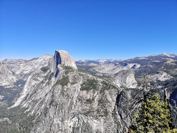 View of Half Dome in Yosemite National Park against a clear blue sky.